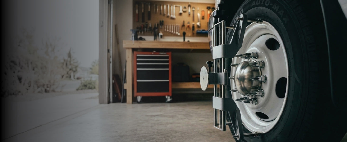 AutoSolo rim clamp seated on a dually wheel in a home garage, locator pins hooked on the rim edge