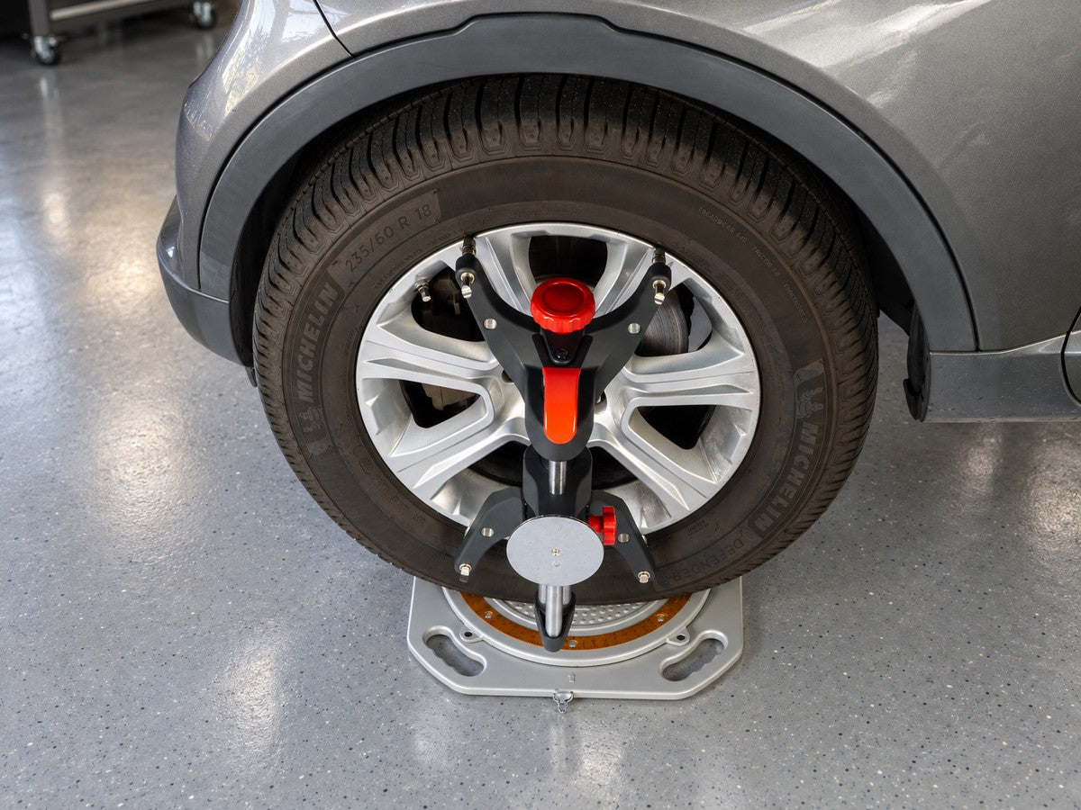 AutoSolo ONYX PRO wheel clamp mounted to a front wheel, sitting on a turn plate