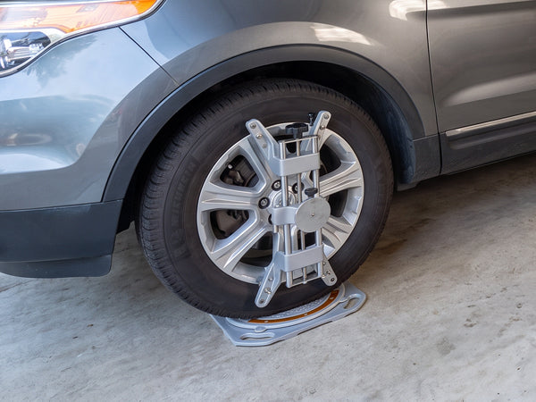 AutoSolo ASWG001 wheel clamp mounted to a front wheel, sitting on a turn plate