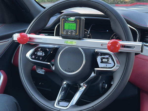 AutoSolo digital steering level on the steering wheel with the wheel holder and brake pedal holder alongside